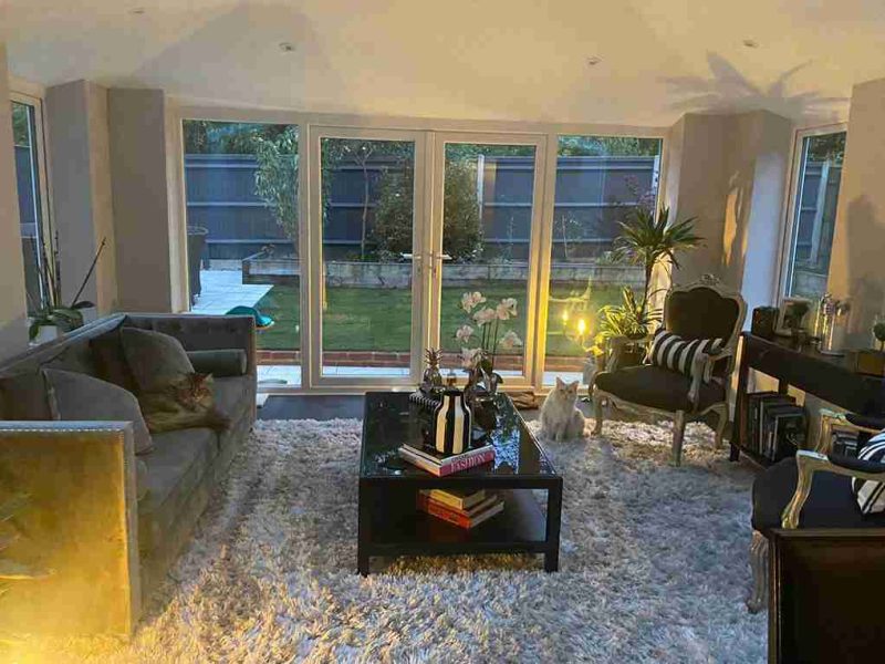 Interior of 365 warm roof conservatory with white french doors and low lighting.